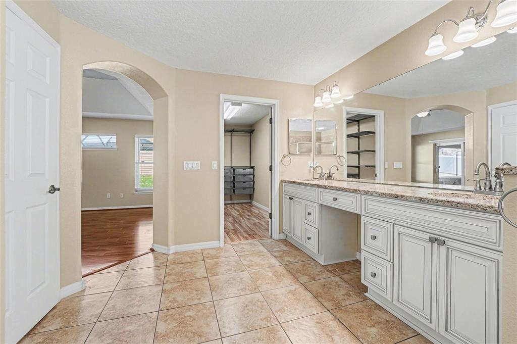 122 Costa Loop Auburndale, FL 33823 - Photo 22 of 30 a large bathroom with a granite countertop sink mirror and a