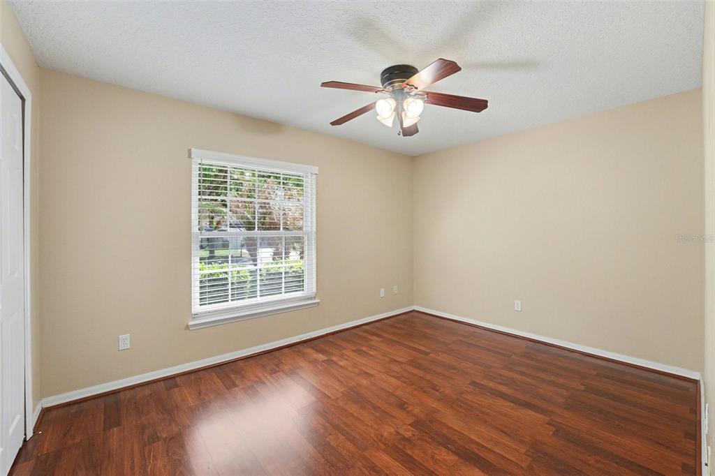 122 Costa Loop Auburndale, FL 33823 - Photo 26 of 30 an empty room with wooden floor chandelier fan and windows