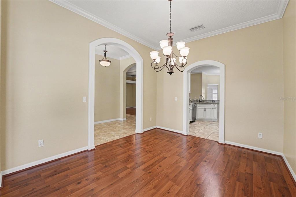 122 Costa Loop Auburndale, FL 33823 - Photo 5 of 30 a view of a livingroom with a chandelier fan front door and wooden floor