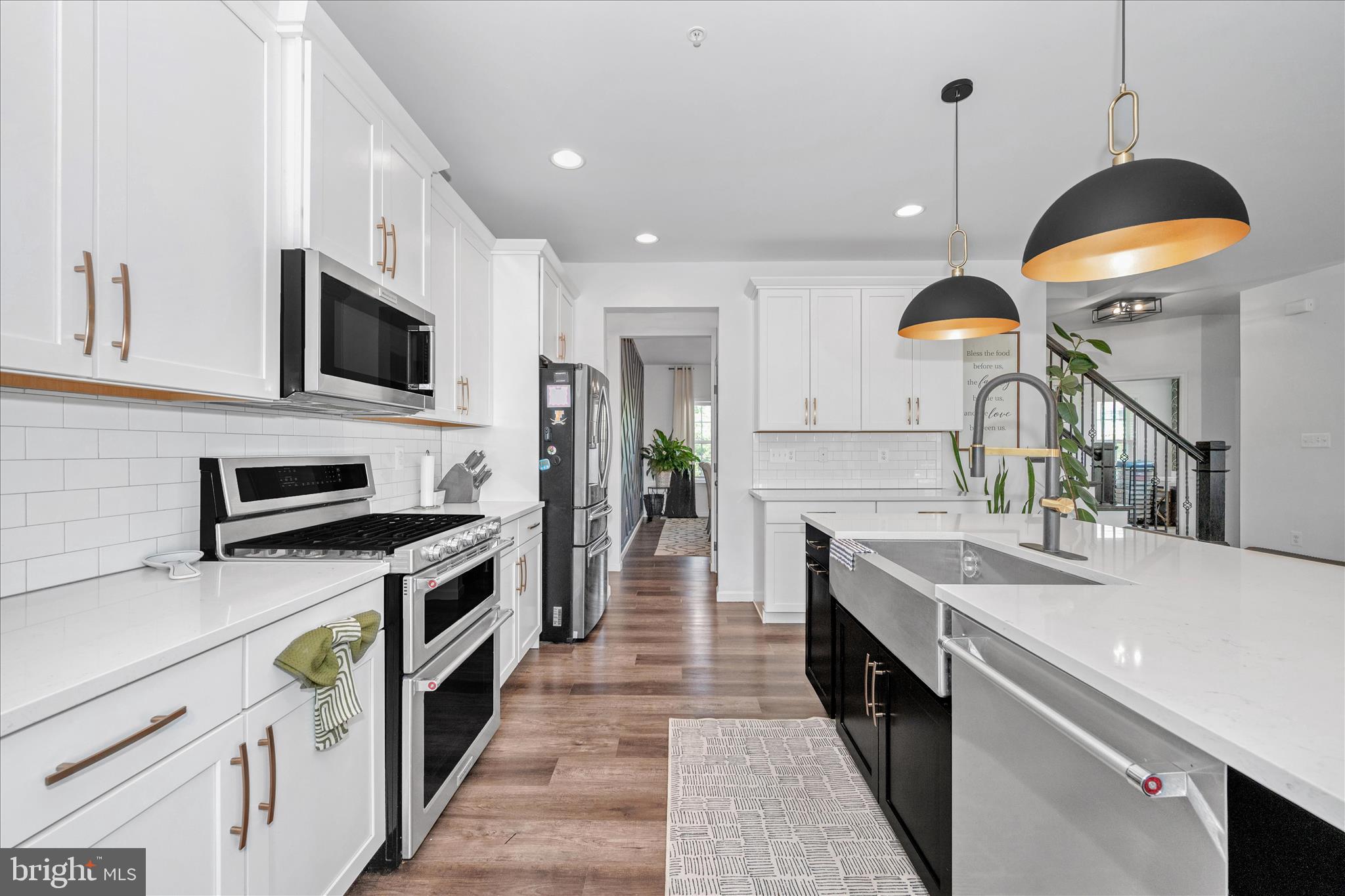 1388 Rocky Springs Road Frederick, MD 21702 - Photo 20 of 97 a kitchen with stainless steel appliances granite countertop a sink a stove top oven a refrigerator with wooden floors