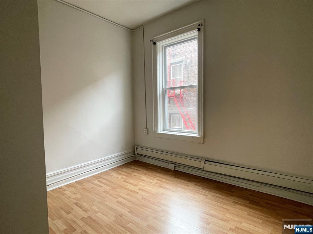 10 Hilliard Avenue, Unit 5 Edgewater, NJ 07020 - Photo 11 of 12 an empty room with wooden floor and windows