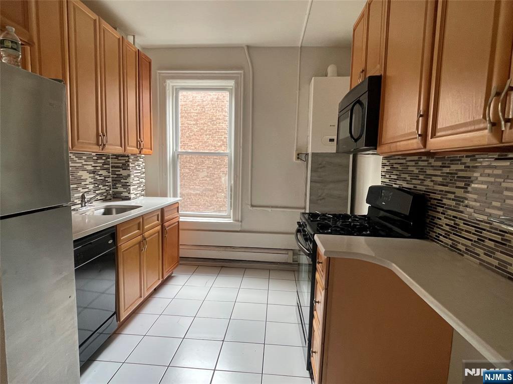10 Hilliard Avenue, Unit 5 Edgewater, NJ 07020 - Photo 2 of 12 a kitchen with stainless steel appliances a sink stove and cabinets