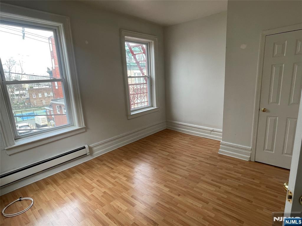 10 Hilliard Avenue, Unit 5 Edgewater, NJ 07020 - Photo 4 of 12 a view of an empty room with wooden floor and a window
