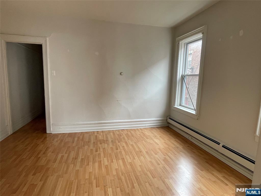 10 Hilliard Avenue, Unit 5 Edgewater, NJ 07020 - Photo 6 of 12 an empty room with wooden floor and windows