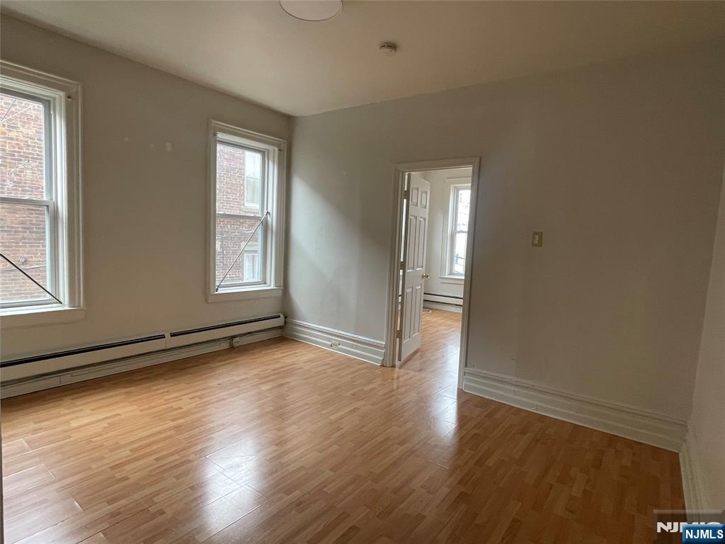 10 Hilliard Avenue, Unit 5 Edgewater, NJ 07020 - Photo 7 of 12 an empty room with wooden floor and windows
