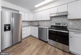 a kitchen with stainless steel appliances granite countertop a stove a refrigerator and a microwave