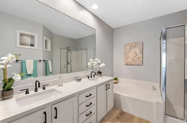 a bathroom with a tub double sink and mirror