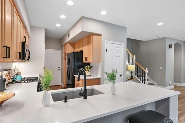 a dining hall with stainless steel appliances kitchen island granite countertop a large kitchen island a stove and a sink