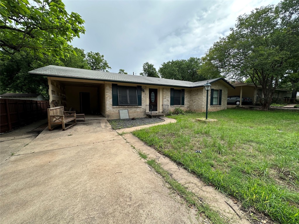 a front view of house with yard and trees in the background