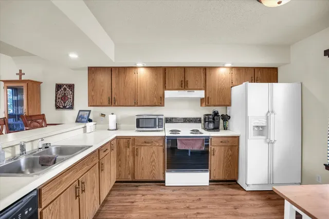 a kitchen with stainless steel appliances a sink a stove a refrigerator and cabinets