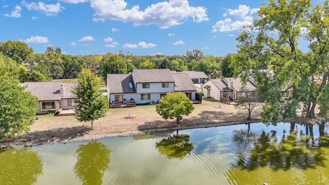 an aerial view of residential houses with outdoor space and lake view