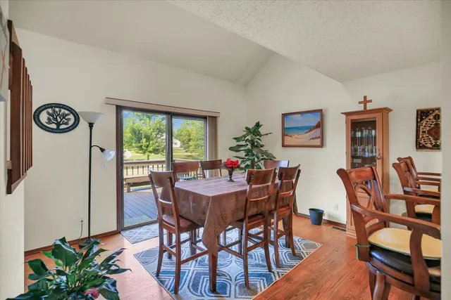 a view of a dining room and livingroom with furniture wooden floor and a rug