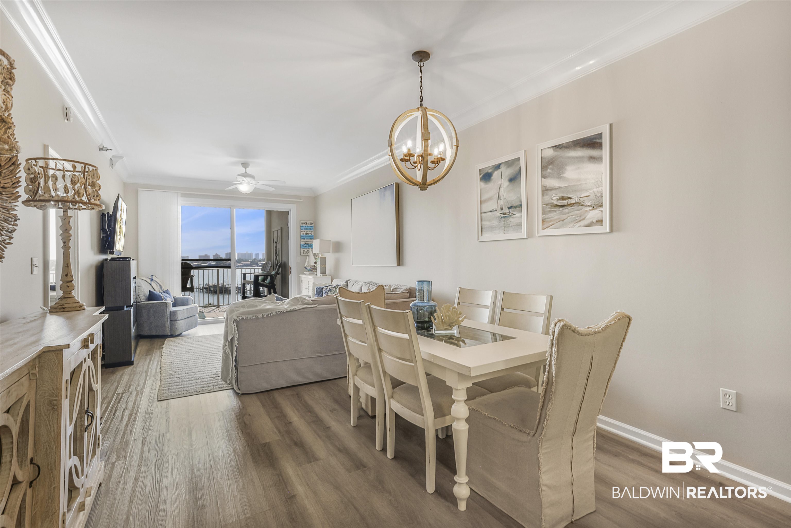 Dining space with a chandelier, ceiling fan, wood finished floors, and crown molding