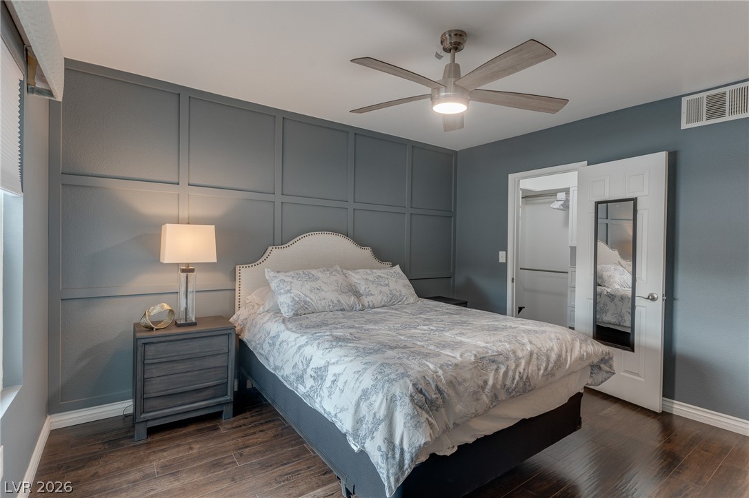 7255 West Sunset Road, Unit 2155 Las Vegas, NV 89113 - Photo 14 of 21 Bedroom with a decorative wall, a ceiling fan, dark wood-type flooring, and a spacious closet