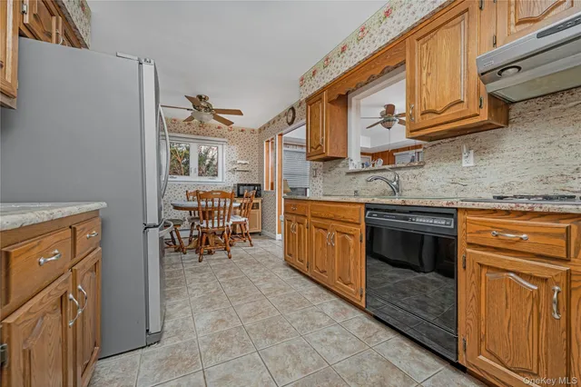 a kitchen with stainless steel appliances granite countertop a stove top oven a refrigerator and a dining table