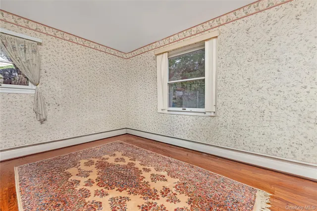 a view of a room with wooden floor and a window