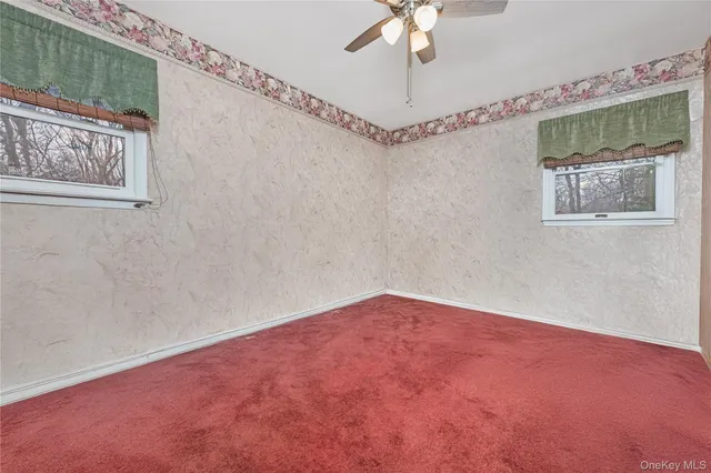 a view of an empty room with a chandelier fan