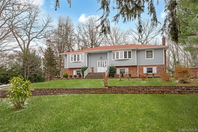 a view of a house with a big yard and large trees