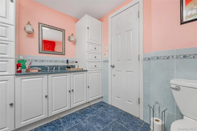 a bathroom with a granite countertop sink mirror vanity and toilet
