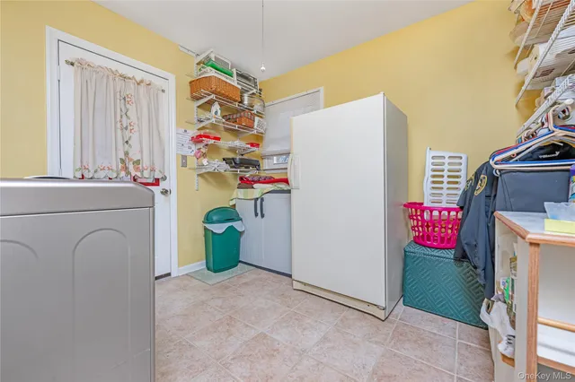 a utility room with fridge and washer