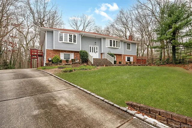 a front view of a house with a garden and trees