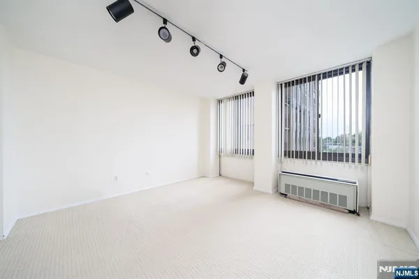 an empty room with a window and mirror