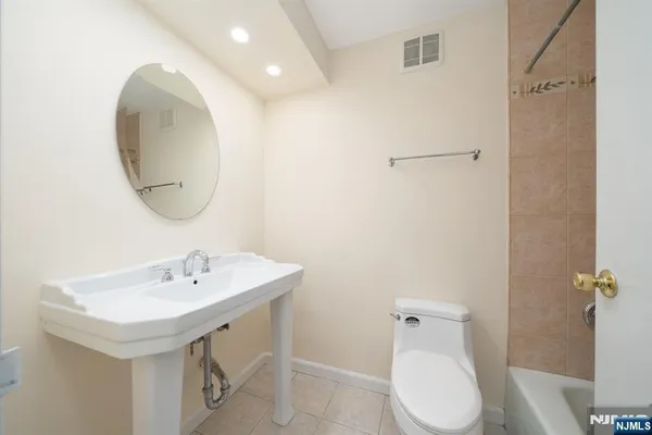 a bathroom with a sink a toilet and mirror