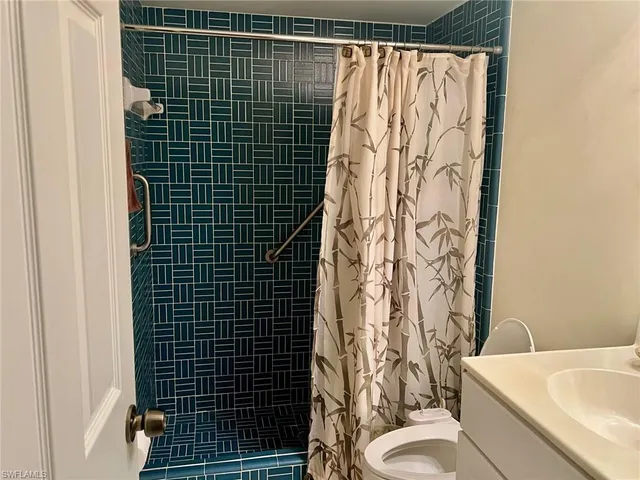 a bathroom with a toilet and shower curtain
