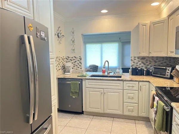 a kitchen with stainless steel appliances a refrigerator sink and cabinets