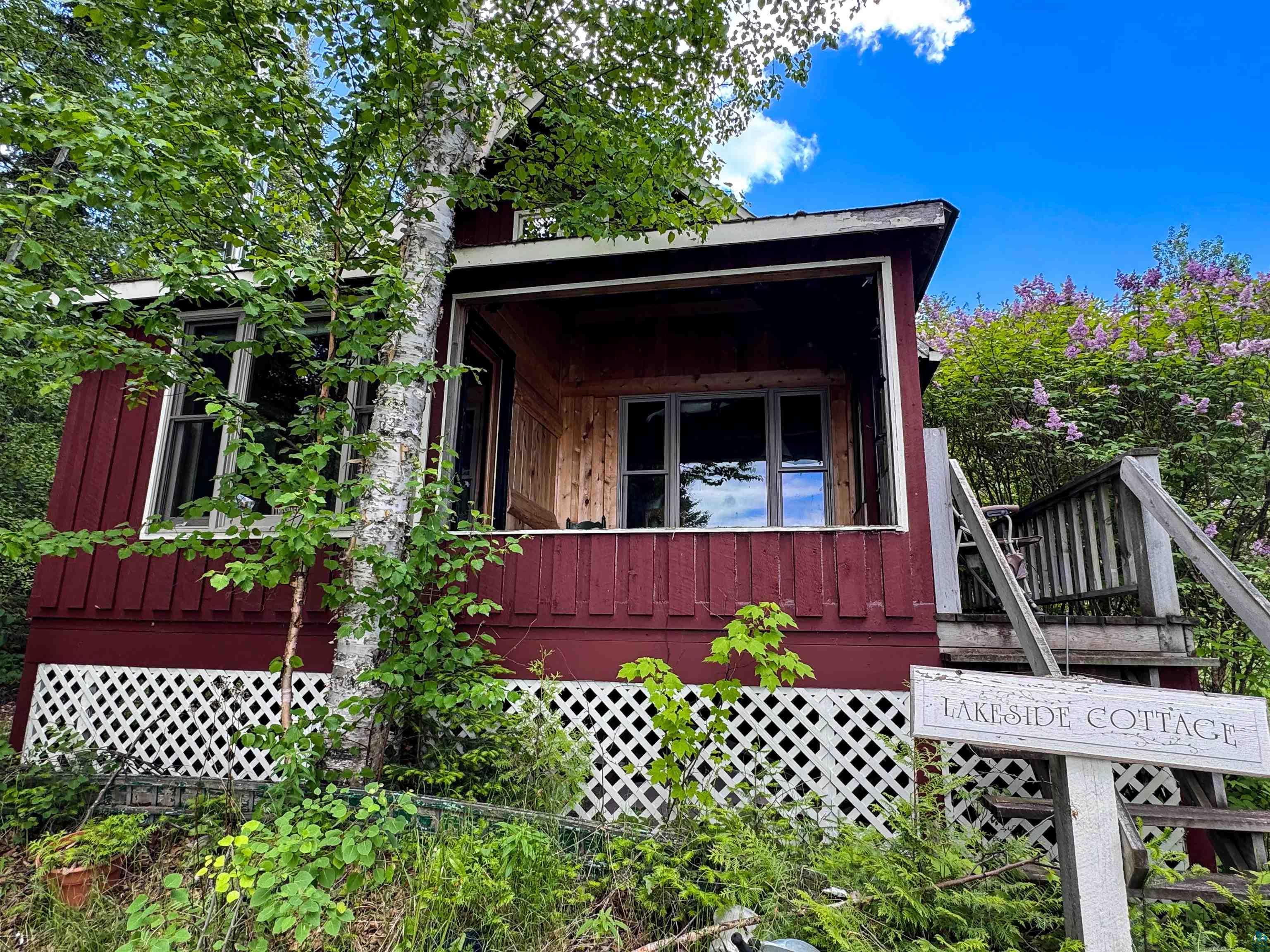465 South Gunflint Lake Road Grand Marais, MN 55604 - Photo 6 of 46 Red exterior structure featuring white lattice skirting and natural wood steps