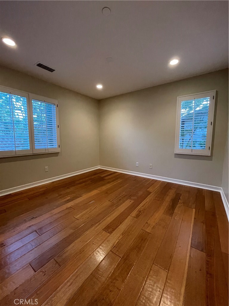 20 Arborside Irvine, CA 92603 - Photo 28 of 45 an empty room with wooden floor and windows