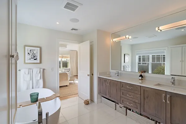 a spacious bathroom with a double vanity sink a mirror and a shower