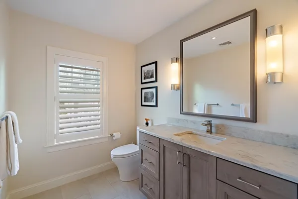 a bathroom with a double vanity sink a toilet and a mirror