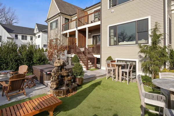 a view of a patio with table and chairs potted plants and large tree