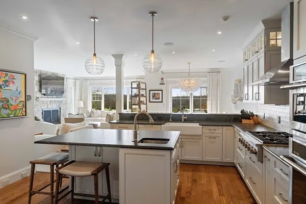 a kitchen with stainless steel appliances granite countertop a sink a stove and a wooden floors