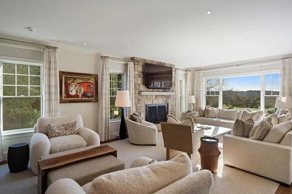 a living room with furniture fireplace and a large window