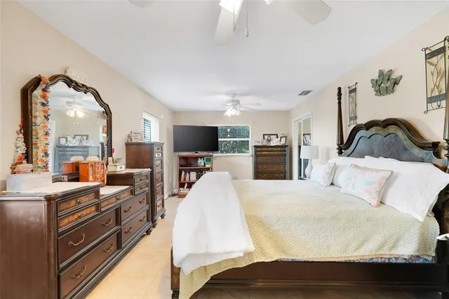 a large bedroom with a bed and a flat screen tv