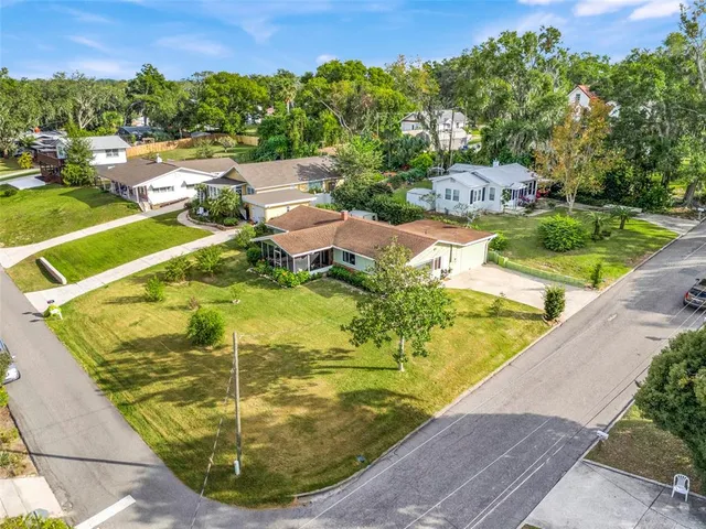 a view of a swimming pool with a yard and large trees