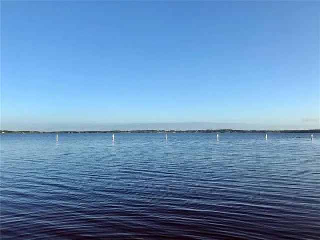 a view of a fountain in front of a house with a yard