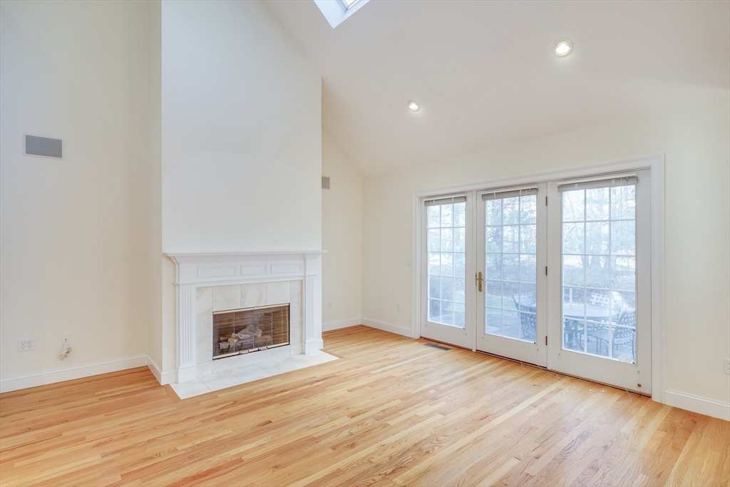 91 Reflection Drive Sandwich, MA 02563 - Photo 15 of 42 an empty room with wooden floor fireplace and windows