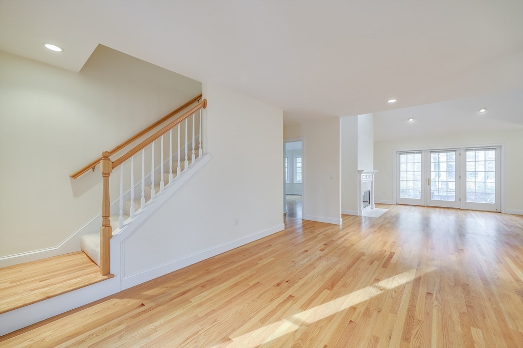 91 Reflection Drive Sandwich, MA 02563 - Photo 17 of 42 a view of an empty room with wooden floor and stairs