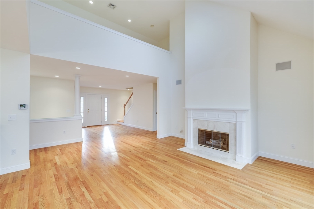 91 Reflection Drive Sandwich, MA 02563 - Photo 4 of 42 a view of an empty room with wooden floor fireplace and a window