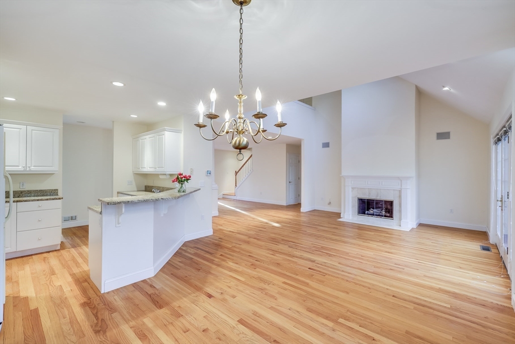 91 Reflection Drive Sandwich, MA 02563 - Photo 6 of 42 a large kitchen with kitchen island a island wooden floor stainless steel appliances and a fireplace