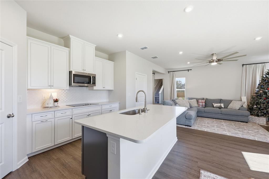 5000 Bear Lake Loop DeLand, FL 32724 - Photo 15 of 45 a view of a kitchen with kitchen island a sink dishwasher a stove with wooden cabinets and floors