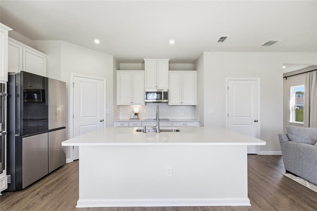 5000 Bear Lake Loop DeLand, FL 32724 - Photo 19 of 45 a large kitchen with kitchen island a counter top space and stainless steel appliances