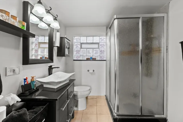 a bathroom with a sink a toilet and shower