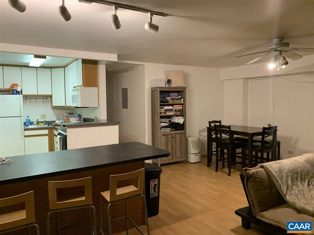 a kitchen with a table chairs microwave and cabinets