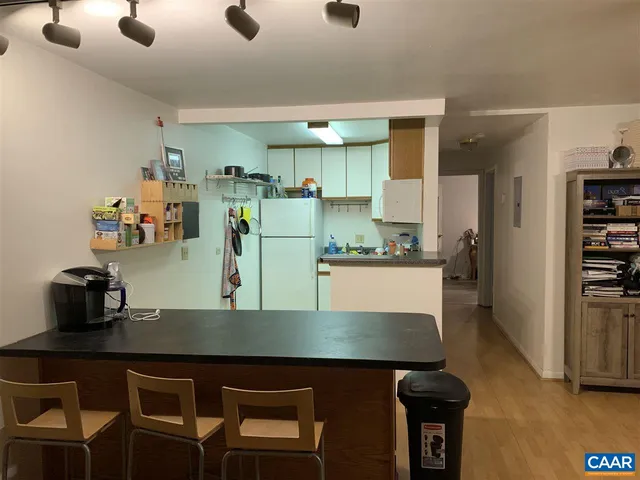 a kitchen with kitchen island a stove a refrigerator and a sink