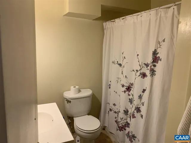 a white toilet sitting next to a shower curtain