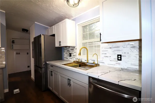 a kitchen with a sink a refrigerator and cabinets